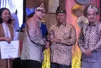 Bupati Lotim, H. M. Sukiman Azmy saat menerima penghargaan dari Menparekraf, Sandiaga Uno. (Istimewa) 