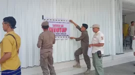 Anggota Satpol PP memasang stiker 