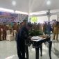 Pj Bupati Lombok Timur Lotim, HM. Juaini Taofik saat menandatangani SK pelantikan 88 Kades. (foto:www.lombokini.com)