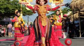 Salah satu peserta karvala menggenakan kain tenun dengan hiasan tembolak merah. (foto:ong)