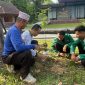 Wakil Rektor IAIH Pancor Bidang Kemahasiswaan, Dr. Abdul Hayyi Akrom, bersama dua orang peserta KKN dan warga setempat menanam pohon. (sumber : istimewa)