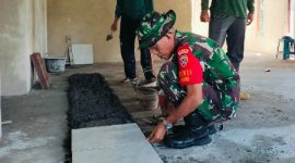 Kapten Inf Anowar, mengawasi pemasangan keramik TPQ Assalam Desa Kesik. (foto: istimewa)