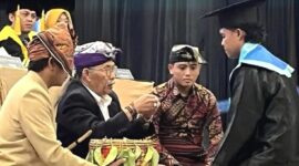 Seorang wisudawan menerima ritual 'Sembeq Buraq' dalam prosesi wisuda unik Institut Elkatarie Lombok Timur, Senin 29 Desember 2025. Ritual adat ini menandai integrasi budaya Sasak dalam kegiatan akademik kampus. (Foto: Lombokini.com).
