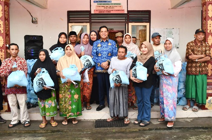 Bupati Lombok Timur Haerul Warisin menyerahkan paket sembako secara simbolis kepada warga menjelang Lebaran 2025. Pemkab Lotim menggelontorkan anggaran Rp 40 miliar untuk 237 ribu paket sembako dalam program bantuan sosial tersebut. (Foto: Lombokini.com/Pemkab Lotim).