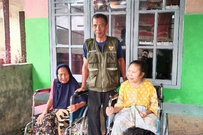 Koordinator Unit Pengumpul Zakat Kecamatan Terara, Saiful Bahri, berfoto bersama penerima bantuan kursi roda. (Foto: Lombokini.com).