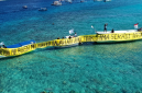 Warga Gili Meno bersama Walhi NTB membentangkan spanduk di laut sambil menuntut pipa air bersih usai tiga tahun krisis, Kamis 21 Mei 2026. (Foto: Lombokini.com).