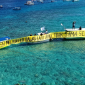 Warga Gili Meno bersama Walhi NTB membentangkan spanduk di laut sambil menuntut pipa air bersih usai tiga tahun krisis, Kamis 21 Mei 2026. (Foto: Lombokini.com).