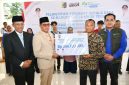 Bupati Lombok Timur, Haerul Warisin, didampingi Sekda dan Kepala Cabang BPJS Ketenagakerjaan, menyerahkan secara simbolis dana jaminan hari tua (JHT) senilai Rp 844 juta kepada perwakilan 87 kepala desa purna tugas Kabupaten Lombok Timur, Rabu 13 Mei 2026. (Foto: Lombokini.com).
