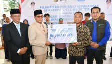 Bupati Lombok Timur, Haerul Warisin, didampingi Sekda dan Kepala Cabang BPJS Ketenagakerjaan, menyerahkan secara simbolis dana jaminan hari tua (JHT) senilai Rp 844 juta kepada perwakilan 87 kepala desa purna tugas Kabupaten Lombok Timur, Rabu 13 Mei 2026. (Foto: Lombokini.com).
