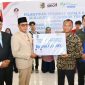 Bupati Lombok Timur, Haerul Warisin, didampingi Sekda dan Kepala Cabang BPJS Ketenagakerjaan, menyerahkan secara simbolis dana jaminan hari tua (JHT) senilai Rp 844 juta kepada perwakilan 87 kepala desa purna tugas Kabupaten Lombok Timur, Rabu 13 Mei 2026. (Foto: Lombokini.com).
