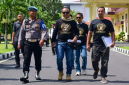 Provos mengawal Direktur LSM Garuda Indonesia, M. Zaini (berkacamata hitam di tengah), saat ia menggelar aksi damai di Polda NTB beberapa waktu lalu. (Foto: Lombokini.com).
