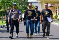 Provos mengawal Direktur LSM Garuda Indonesia, M. Zaini (berkacamata hitam di tengah), saat ia menggelar aksi damai di Polda NTB beberapa waktu lalu. (Foto: Lombokini.com).

