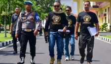 Provos mengawal Direktur LSM Garuda Indonesia, M. Zaini (berkacamata hitam di tengah), saat ia menggelar aksi damai di Polda NTB beberapa waktu lalu. (Foto: Lombokini.com).