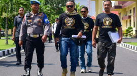 Provos mengawal Direktur LSM Garuda Indonesia, M. Zaini (berkacamata hitam di tengah), saat ia menggelar aksi damai di Polda NTB beberapa waktu lalu. (Foto: Lombokini.com).
