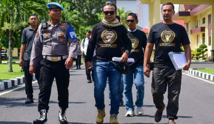 Provos mengawal Direktur LSM Garuda Indonesia, M. Zaini (berkacamata hitam di tengah), saat ia menggelar aksi damai di Polda NTB beberapa waktu lalu.