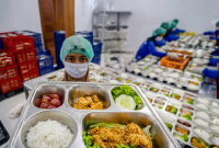 Relawan menyusun menu Makan Bergizi Gratis sebelum mendistribusikannya ke penerima manfaat. (Foto: Lombokini.com).
