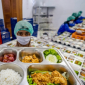 Relawan menyusun menu Makan Bergizi Gratis sebelum mendistribusikannya ke penerima manfaat. (Foto: Lombokini.com).
