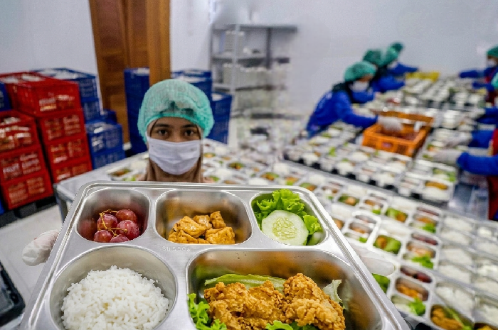 Relawan menyusun menu Makan Bergizi Gratis sebelum mendistribusikannya ke penerima manfaat. (Foto: Lombokini.com).
