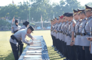 Kapolda NTB Irjen Pol. Kalingga Rendra Raharja meneken berita acara serah terima jabatan delapan pejabat utama dan empat kapolres di Lapangan Bhara Daksa, Senin 13 Juli 2026. (Foto: Lombokini.com/Asman).