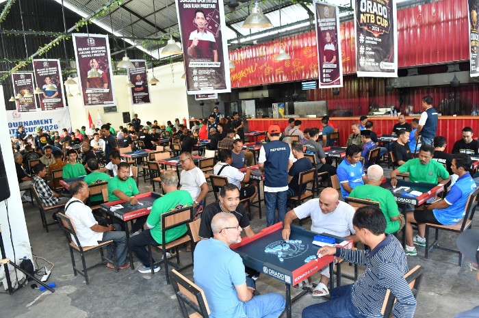 Para peserta turnamen mencurahkan konsentrasi penuh saat mengadu kartu domino di Meekow, Mataram, Ahad 26 Juli 2026. (Foto: Lombokini.com).