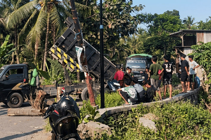 Warga Kalijaga Timur memblokir dua ruas jalan dengan batang kelapa, Ahad 16 Agustus 2026, untuk memprotes Pemda Lombok Timur yang mengingkari janji memperbaiki jalan rusak akibat truk pengangkut galian C. [Foto: Lombokini.com]