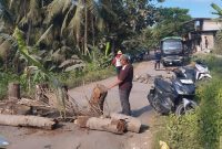 Warga Kalijaga Timur memblokir jalan lintasan truk galian C menggunakan batang kelapa, Ahad 16 Agustus 2026. Aksi ini mereka lakukan untuk mendesak perbaikan jalan rusak di wilayah tersebut. [Foto: Lombokini.com]