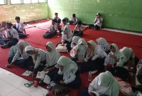 Siswa SMPN 2 Selong sedang mengikuti pelajaran tanpa kursi dan meja.