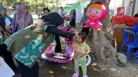 Ketua TP PKK Provinsi NTB Hj. Sinta Agathia M. Iqbal menyapa seorang anak dalam acara cegah stunting di Kantor Desa Pringgabaya Utara, Kecamatan Pringgabaya LombokTimur. (Foto: Lombokini.com)