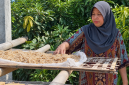 Murnihati sedang menjemur bahan baku trasi, yakni udang rebon.
